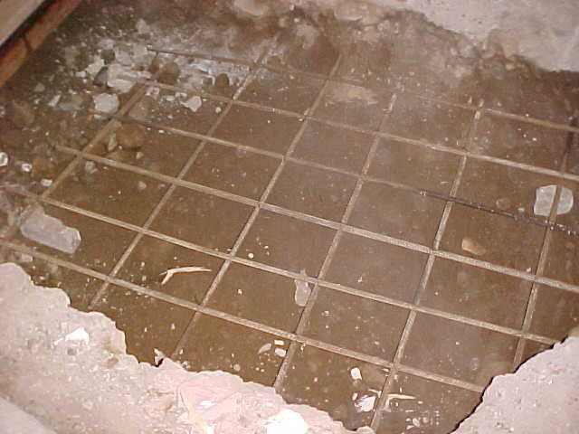 A dirty tile floor with a hole in it
