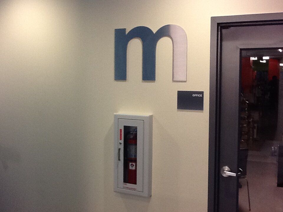 The letter m is on the wall above a fire extinguisher