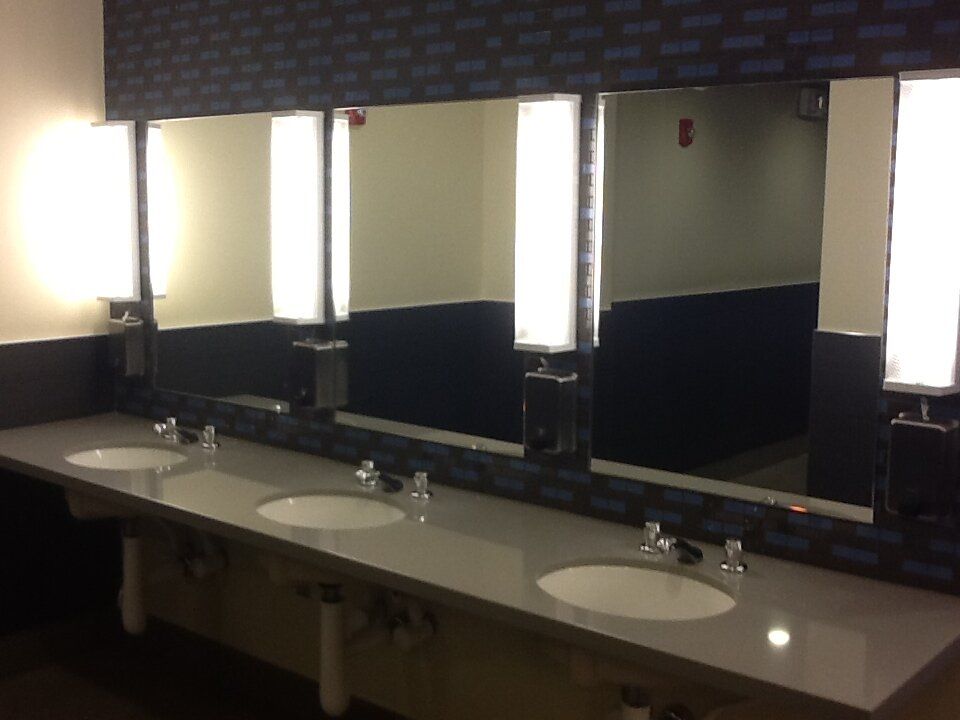 A bathroom with three sinks and three mirrors