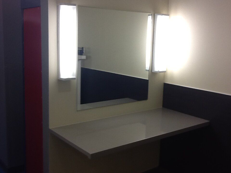 A bathroom with a mirror and two lights on the wall