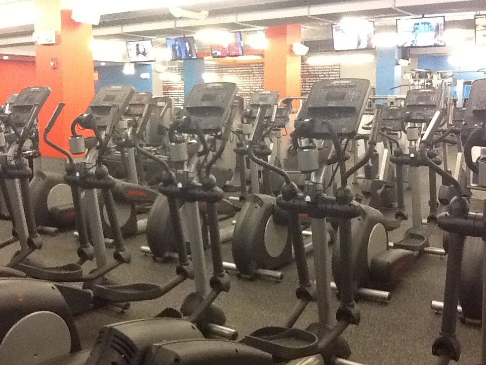 A gym with a lot of ellipticals in it