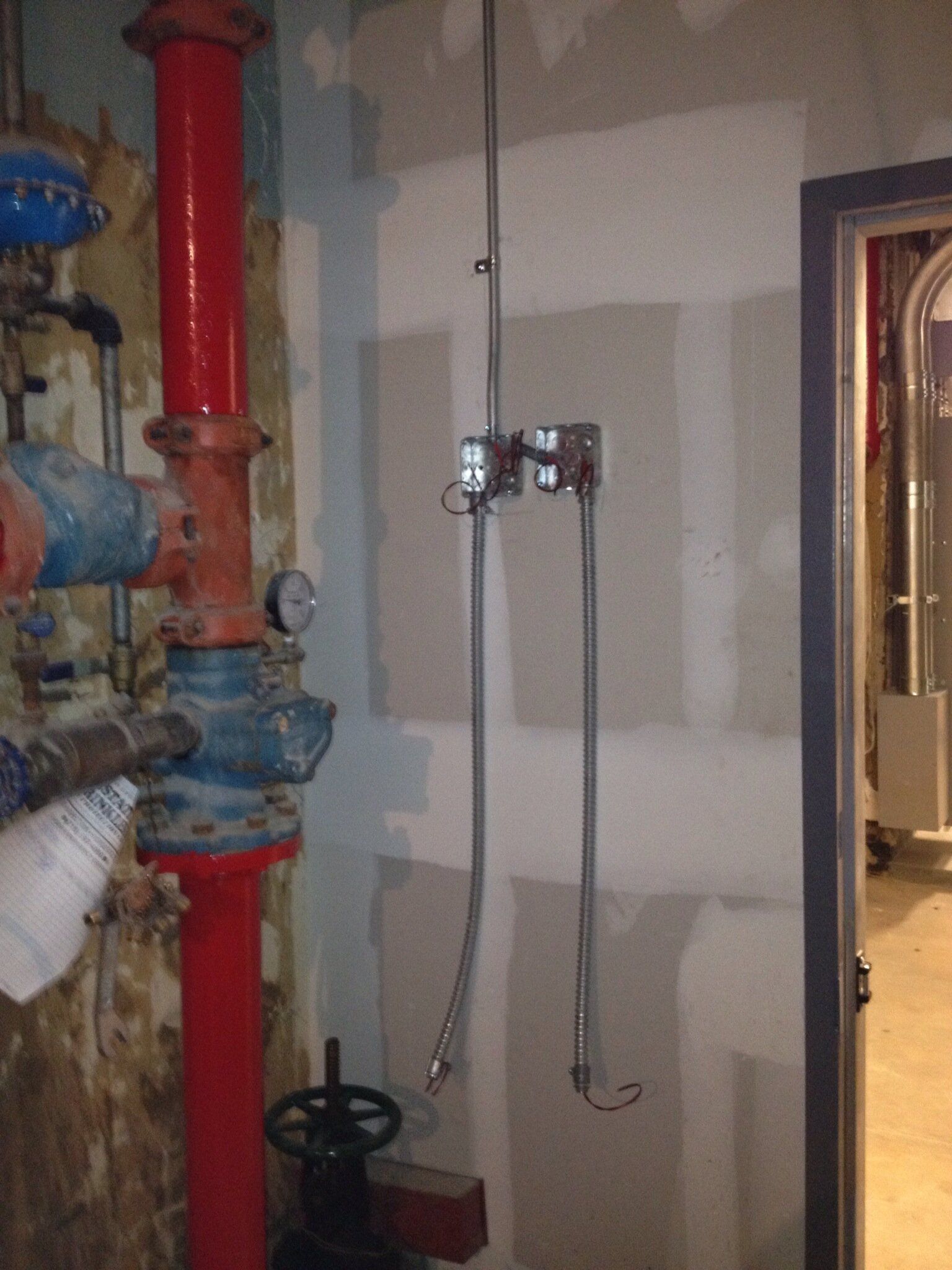 A room with a lot of pipes and a door