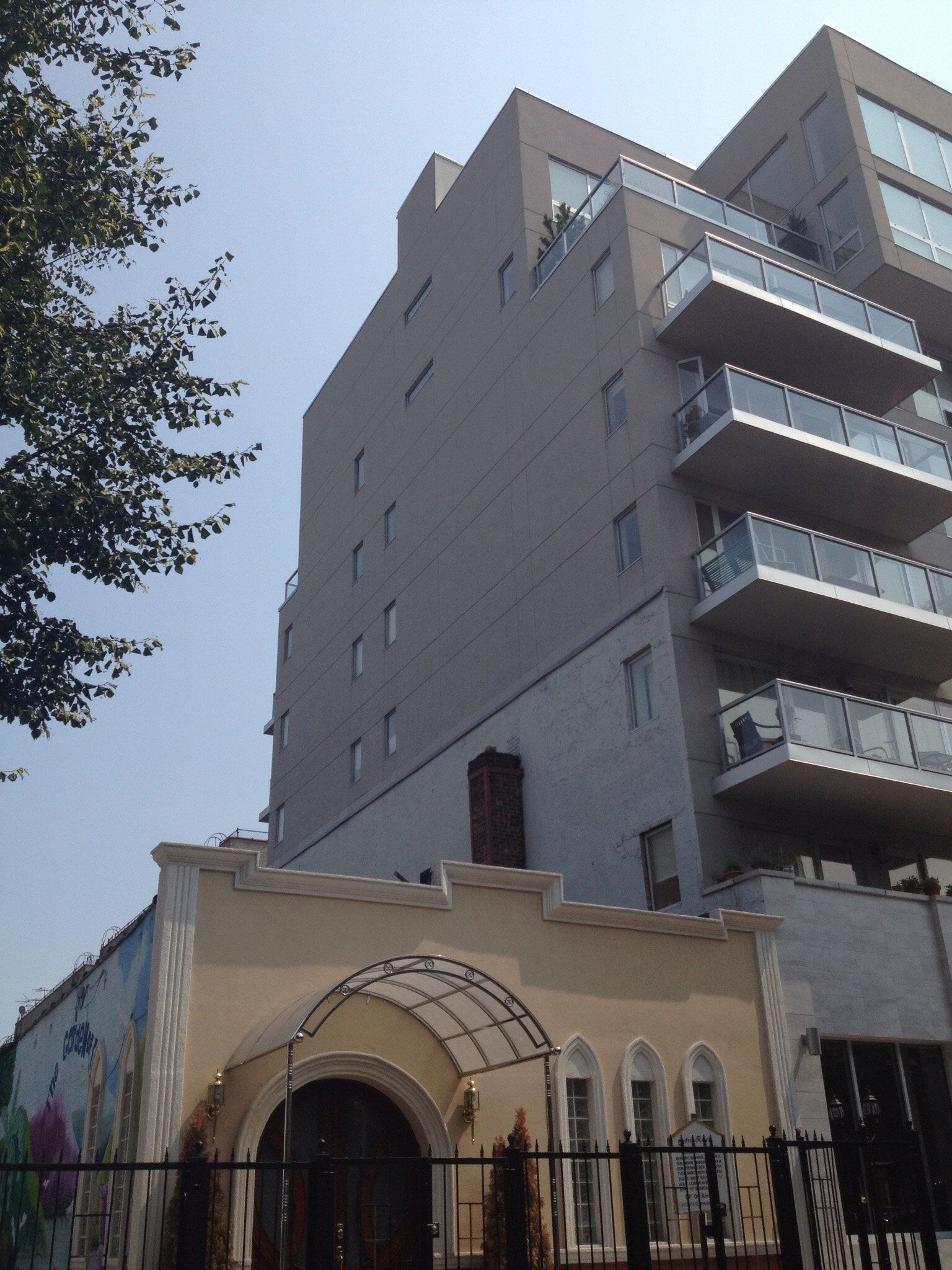 A tall building with balconies and a fence around it