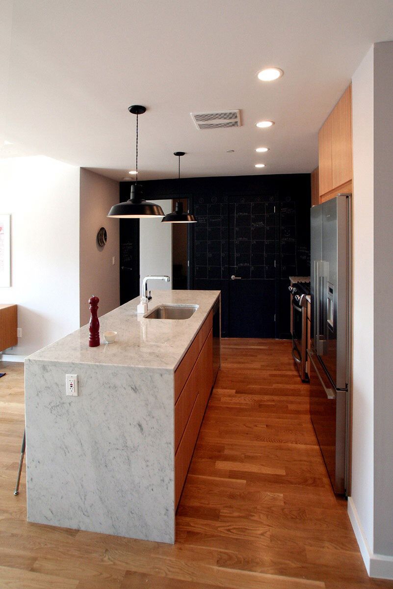 A kitchen with a large island and a marble counter top
