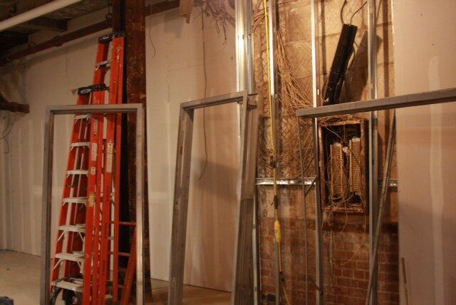 A ladder is sitting in a room next to a wall.