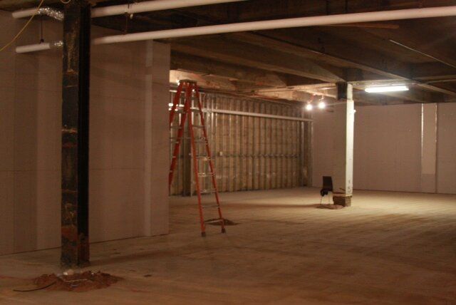 An empty room with a ladder in the middle of it