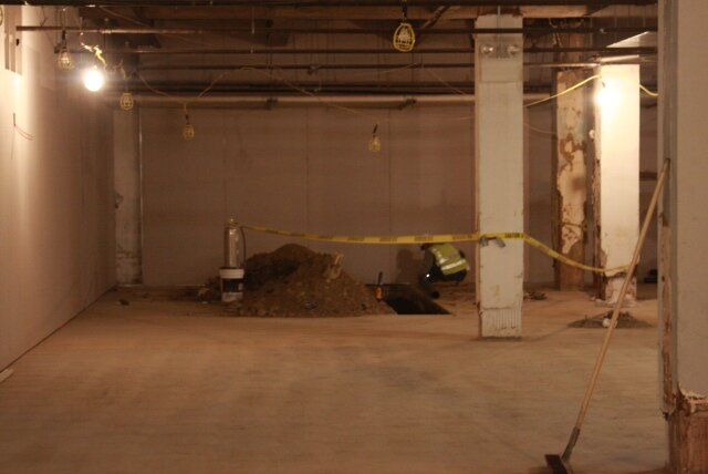 An empty room with a yellow tape around the pillars