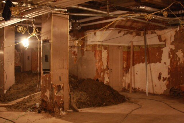 An empty room with a pile of dirt in the middle of it