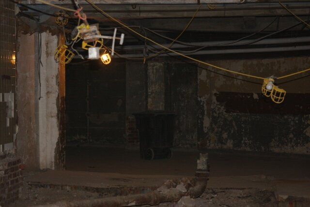 A very dark room with a lot of wires hanging from the ceiling.
