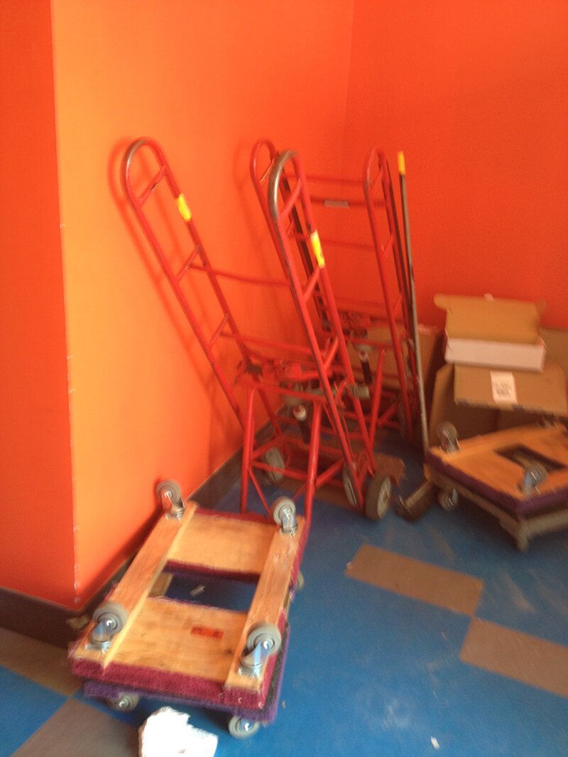 A room with a bunch of moving carts and boxes on the floor