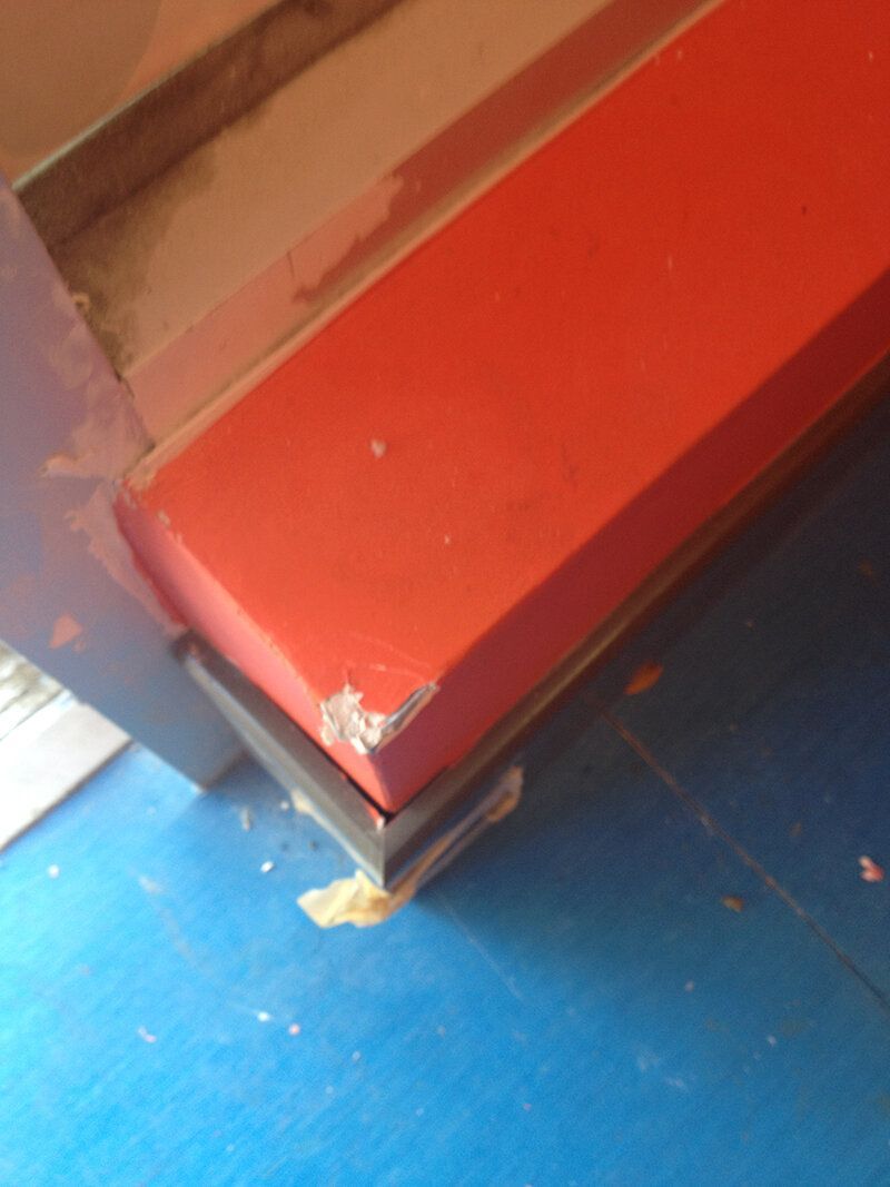 A red bench is sitting on a blue floor.