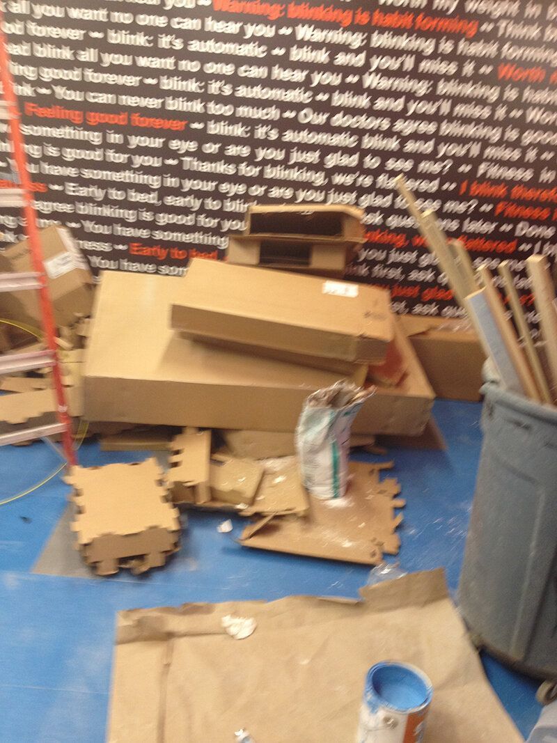 A pile of cardboard boxes on a blue floor