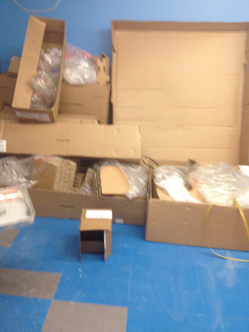 A pile of cardboard boxes on a blue floor