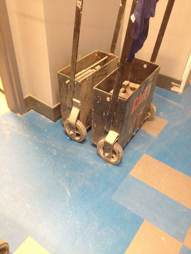 Two carts on a blue tiled floor with one that says ' a & m ' on it