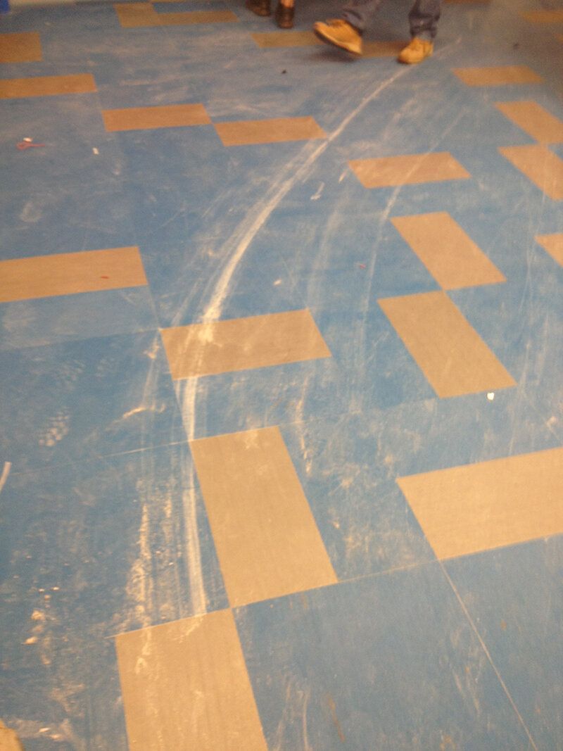 A person standing on a blue and tan checkered floor