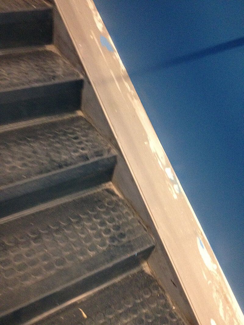 A close up of a set of stairs with a blue wall in the background.