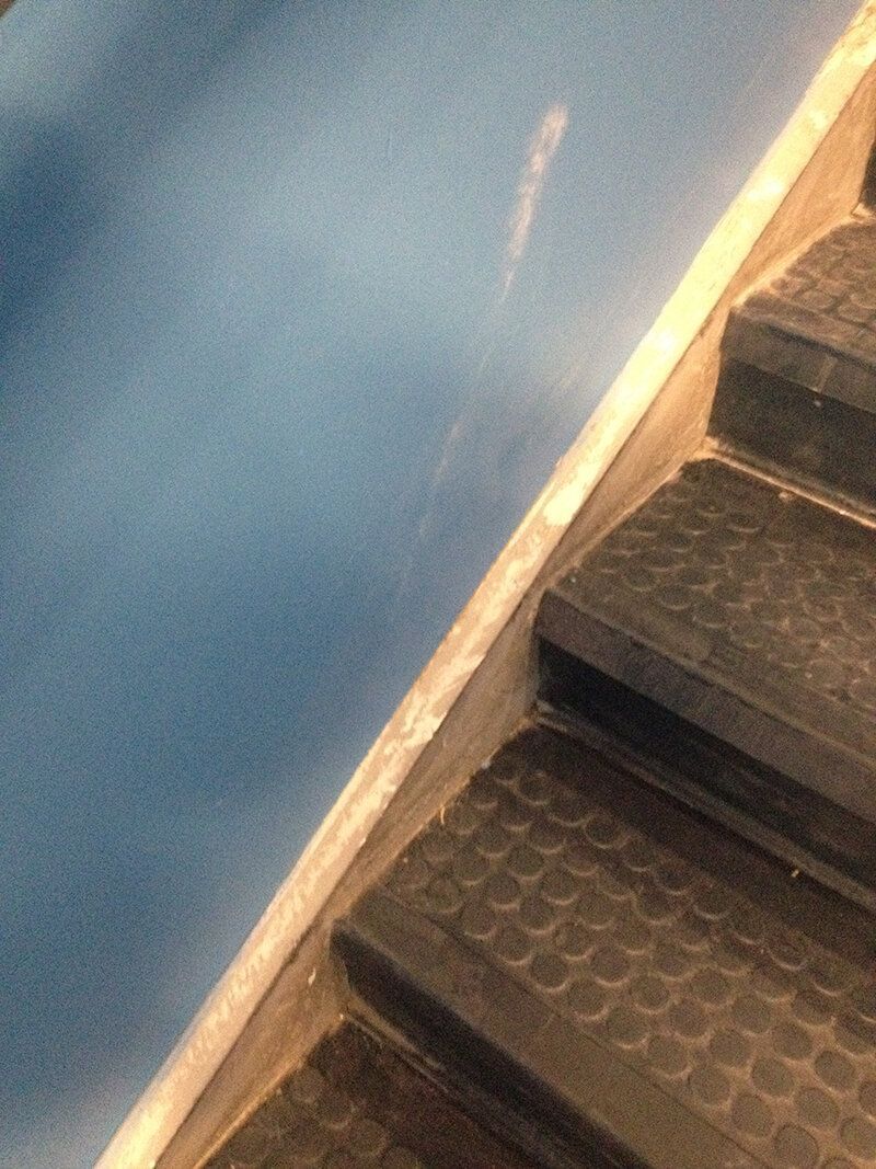 A close up of a set of stairs with a blue wall in the background.