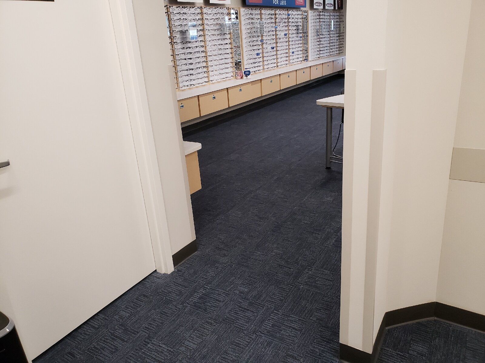 A hallway with a blue carpet and a white door