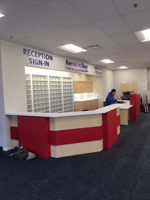 A man sits at a red and white reception desk