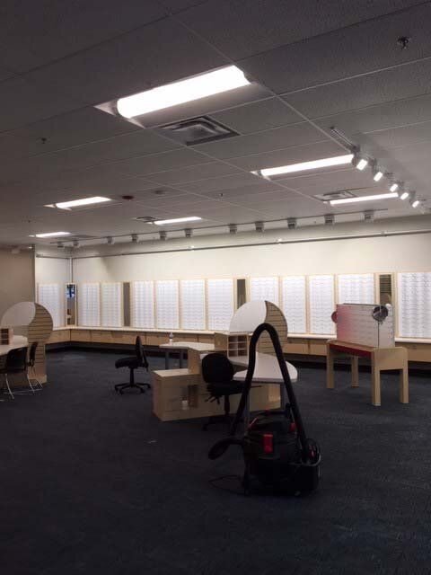 A vacuum cleaner is in the middle of an empty office