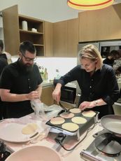 A man and a woman are preparing food in a kitchen