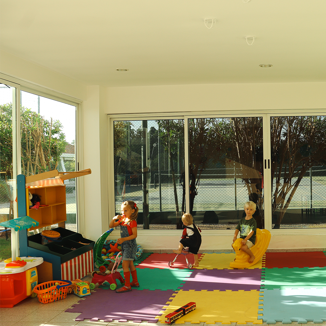 Duas crianças estão brincando em uma sala com muitos brinquedos