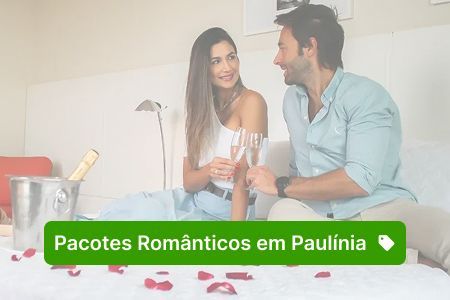 Casal em um quarto de hotel com champanhe, comemorando. Botão verde com os dizeres 