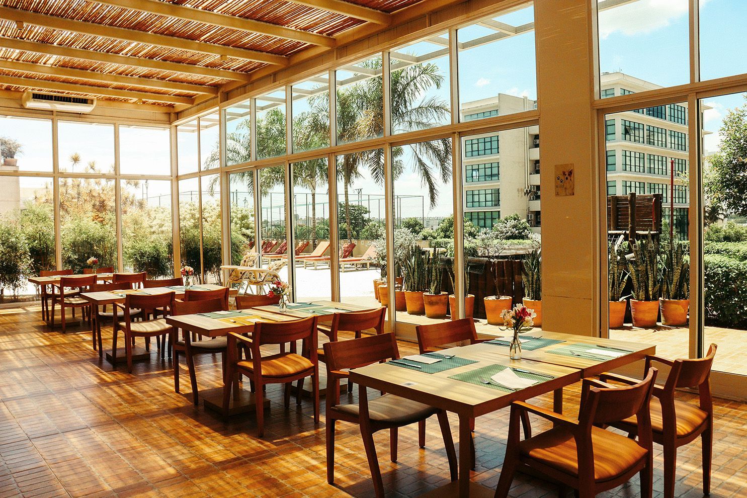 Um restaurante com mesas e cadeiras e muitas janelas