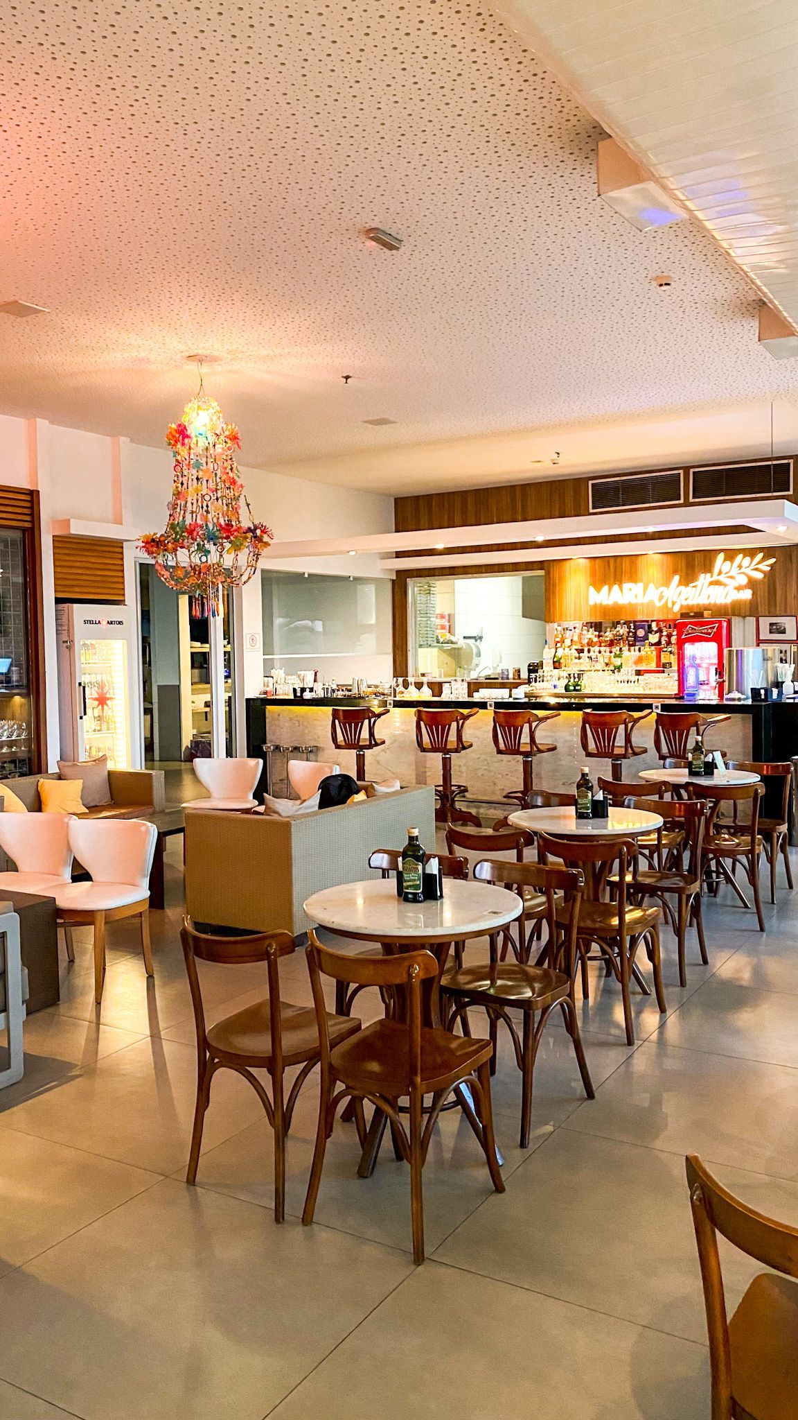 Um restaurante com mesas e cadeiras e um lustre pendurado no teto.