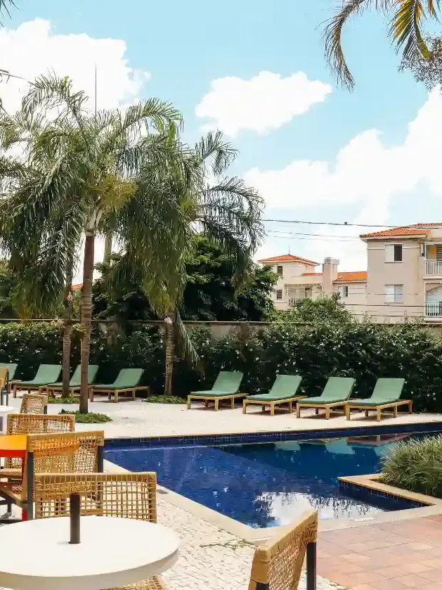 Spa coberto com piscina, espreguiçadeiras e vista para a cidade.