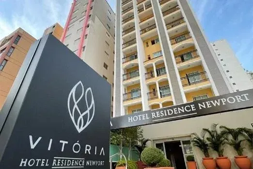Exterior do edifício do Hotel Vitória Newport com o logotipo em primeiro plano.
