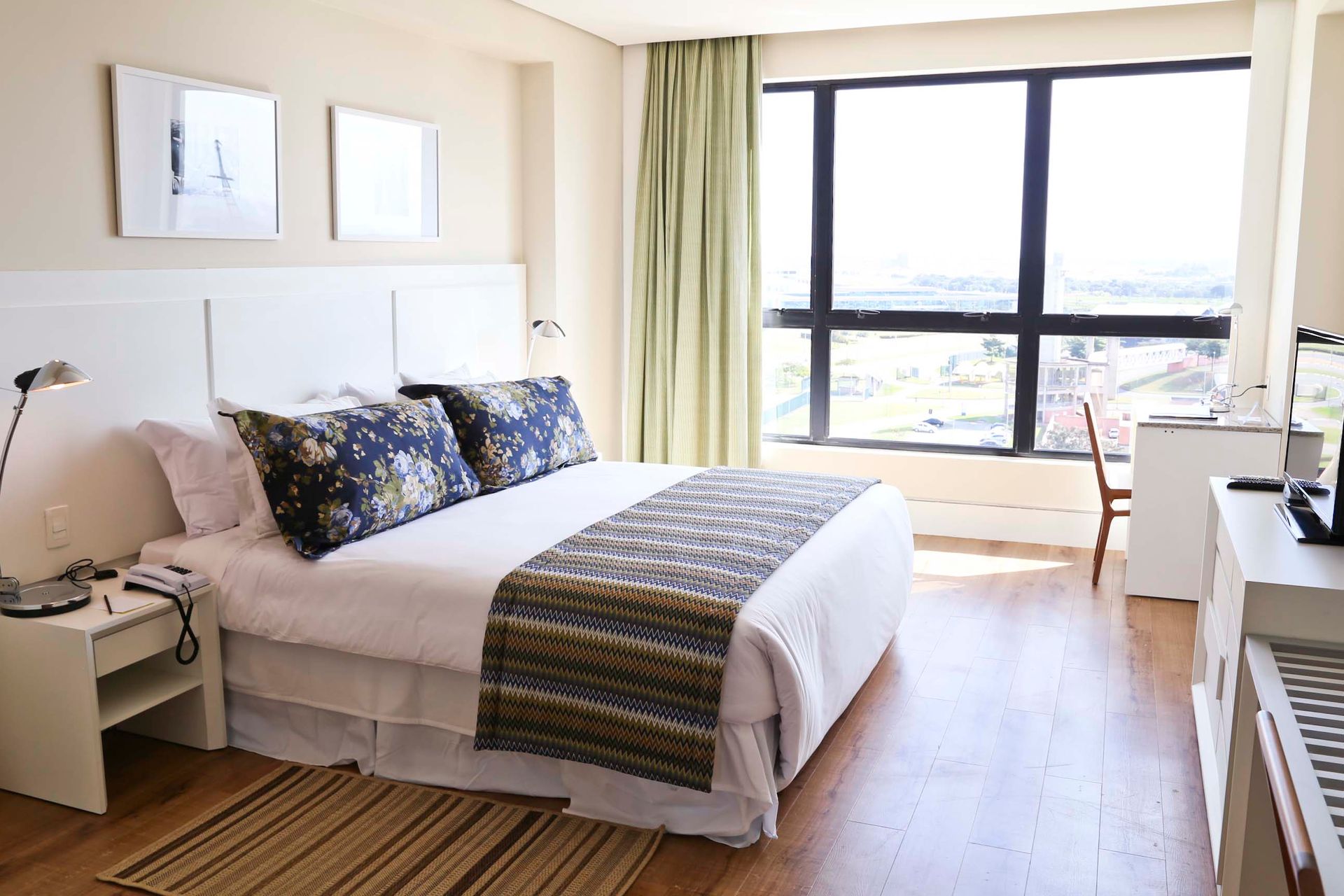 Um quarto de hotel com uma cama grande e uma janela grande.