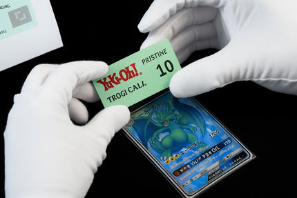 Una persona che indossa guanti bianchi tiene in mano una carta con il numero 10