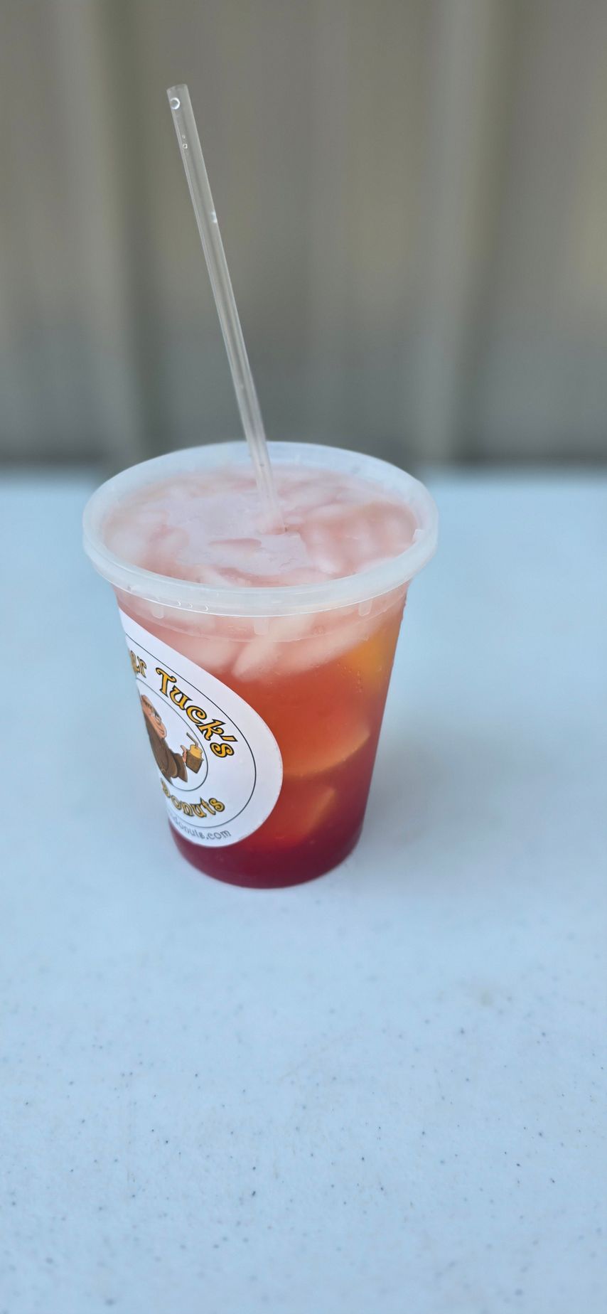Cup of coffee with swirls, coffee beans, sugar cubes, ground coffee, milk, and wooden spoon.