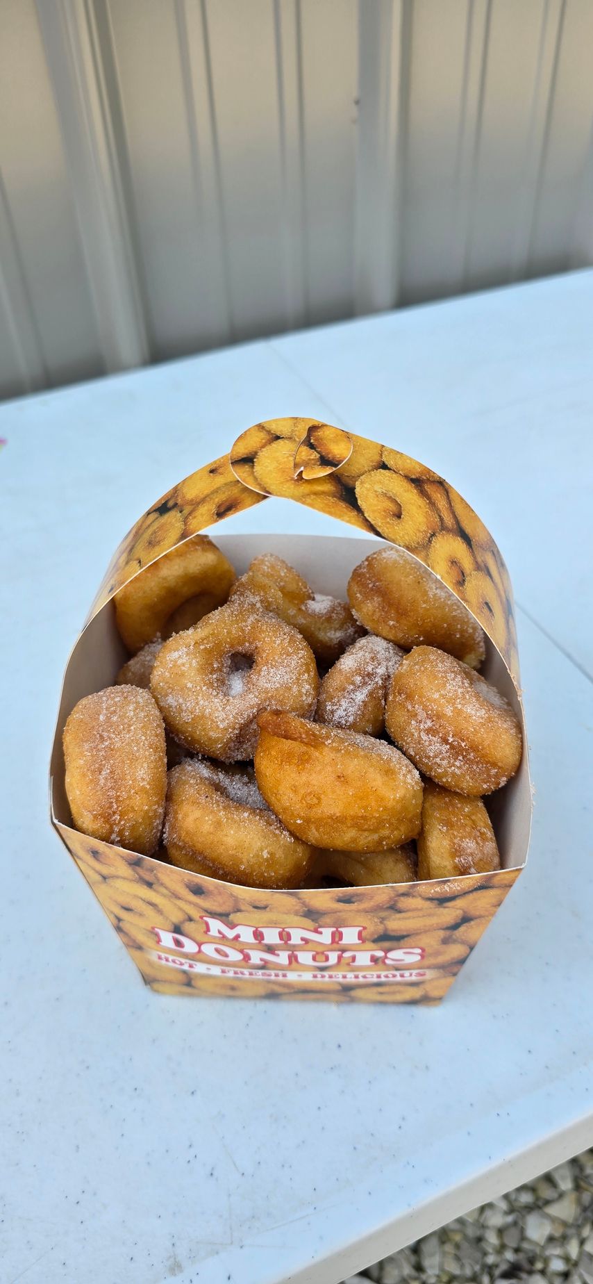 Cup of donuts with berries on a saucer, mint leaf garnish. Chocolate and glazed donuts.