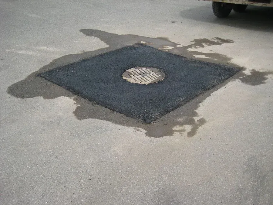 A manhole cover in the middle of a road