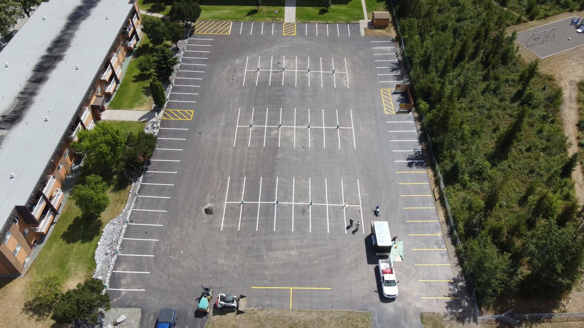 An aerial view of a parking lot with a building in the background