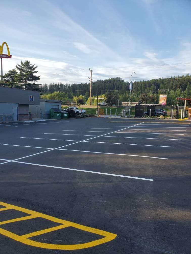 A parking lot with a mcdonald 's in the background