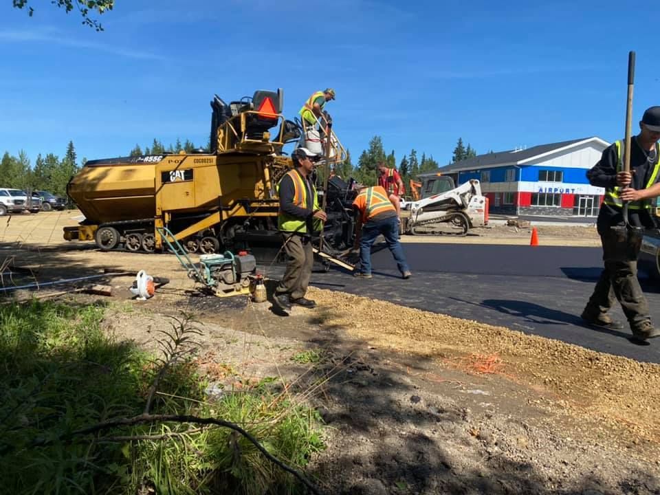 A group of construction workers are working on a road.