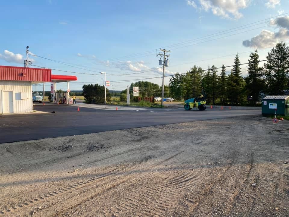 A road is being paved in front of a gas station.