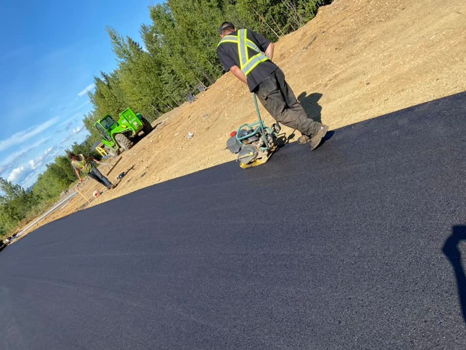 A man is walking down a road with a machine on it.