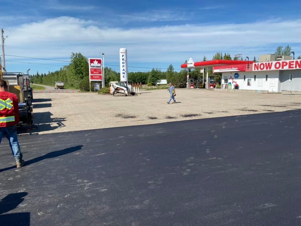 A gas station is now open and people are walking in front of it.