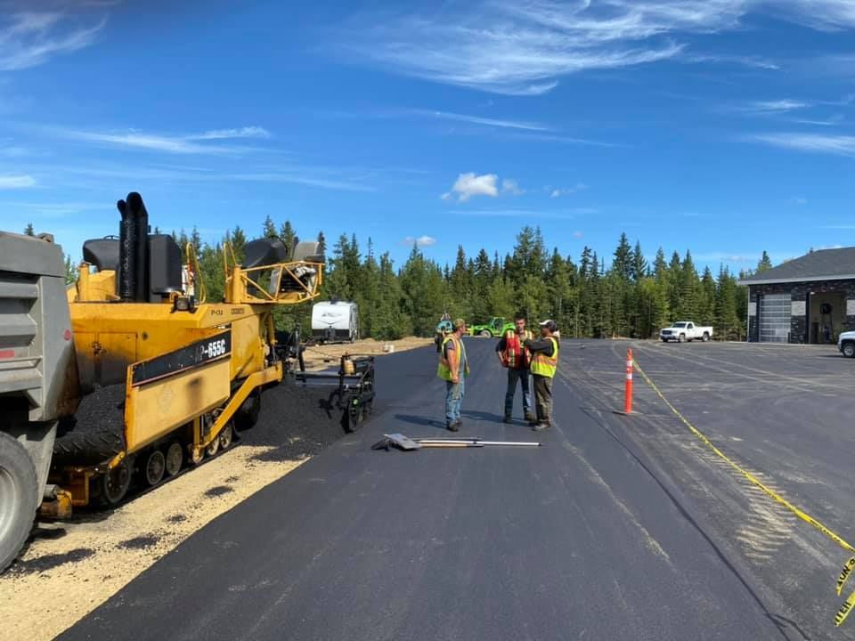 A group of construction workers are working on a road.