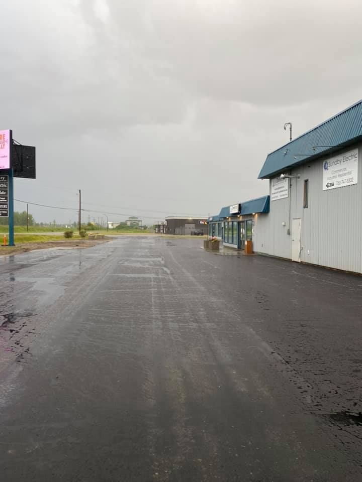 An empty road with a building in the background and a cloudy sky