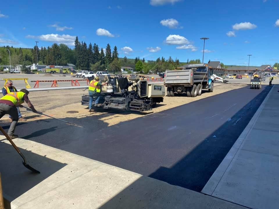 A group of construction workers are working on a road.