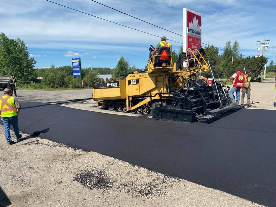 A group of construction workers are working on a road.