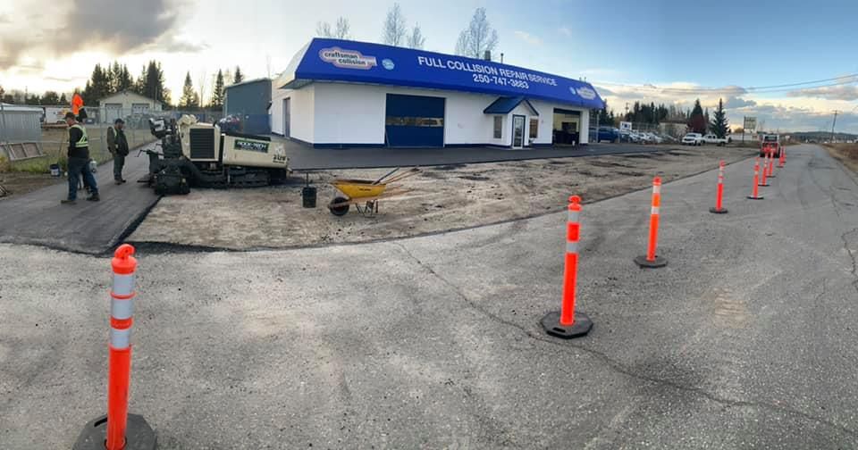 A large white building with a blue roof is being built.