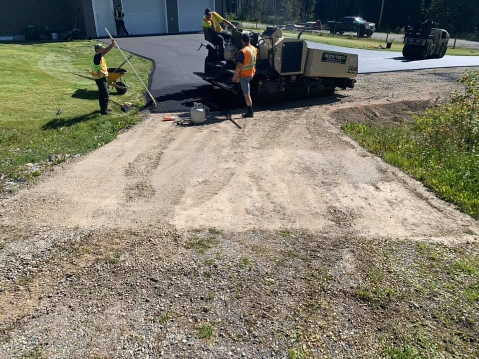 A group of people are working on a driveway.