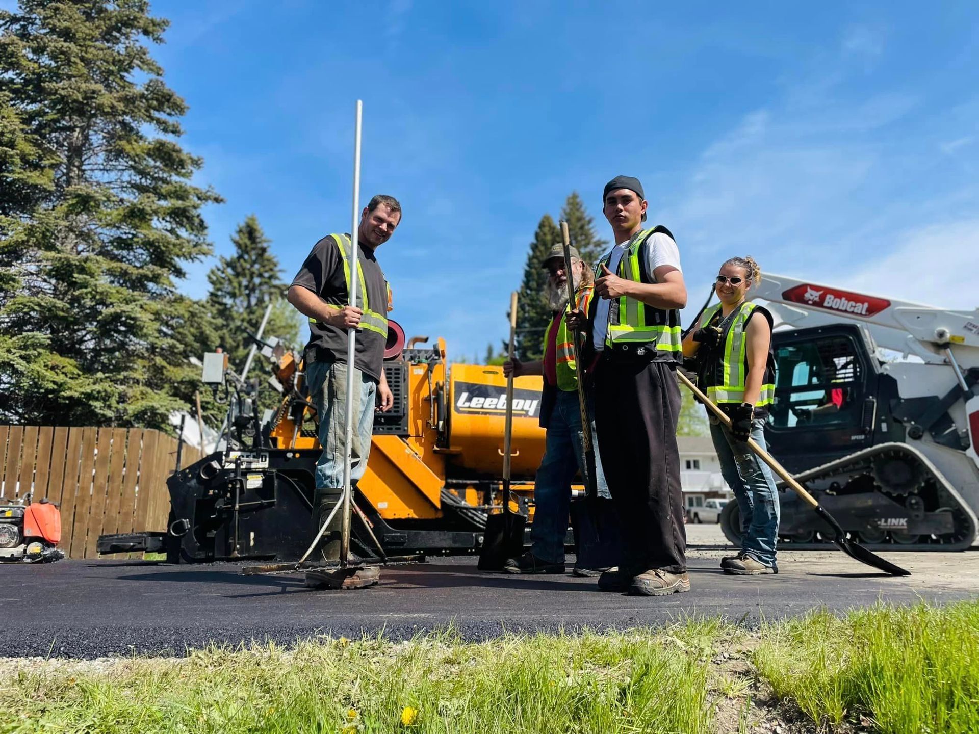 A group of construction workers are working on a road.