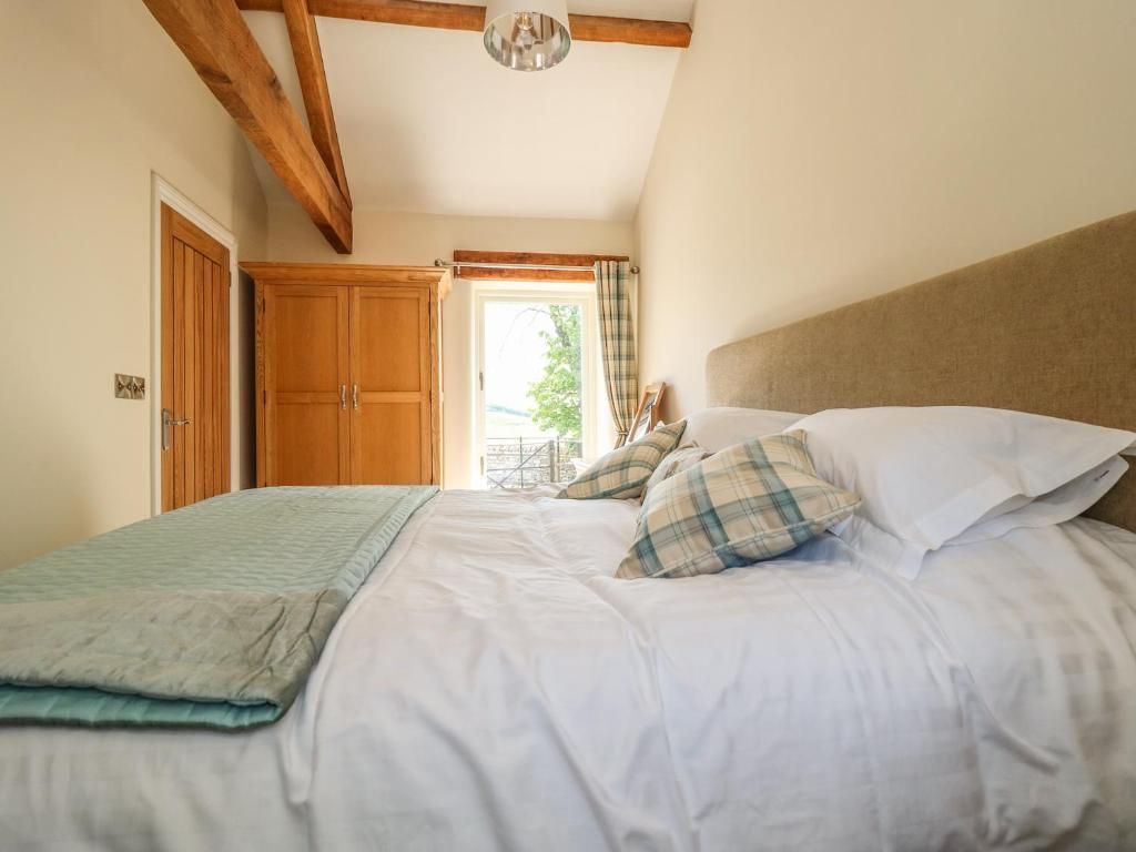 Bedroom with a large bed, wooden beams, wardrobe, and open door to a balcony.